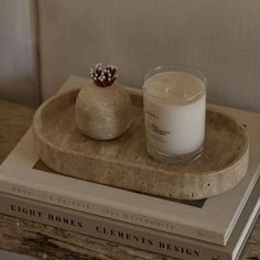 a candle sitting on top of a book next to a glass filled with milk in front of it