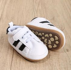 Introducing our adorable baby shoes, this pair features a stylish combination of white and black stripe pattern. Crafted with utmost care, these shoes are designed to provide comfort and support for your little one's tiny feet. The classic stripe design adds a touch of charm to any outfit, making them perfect for both casual and formal occasions. With their soft and durable materials, these white and black shoes are a must-have addition to your baby's wardrobe. White Non-slip Booties With Round Toe, White High-top Booties With Soft Sole, White Lace-up Booties With Soft Sole, Casual High-top White Booties, Casual White Booties With Rubber Sole, White Casual Booties With Rubber Sole, White Round Toe Booties With Rubber Sole, Casual White High-top Booties, Non-slip White High-top Canvas Shoes