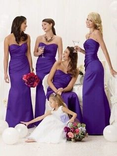 a group of women in purple dresses standing next to each other