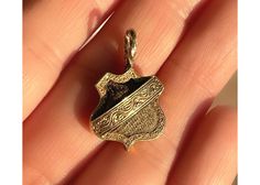 "ERA: Victorian, antique, modern conversion to pendent using antique component MATERIAL: 16k yellow gold, human hair LENGTH: 2.5cm WEIGHT: 2.16 grams CONDITION: Very good antique condition HALLMARKS: \"E.G.M.\" \"DW\" \"16K\" This is a truly incredible work of Victorian art! Made out of 16k yellow gold, with a delicately chased front, this shield holds real human hair. This likely served as a mourning, or sentimental, piece. It was originally a stickpin, however I had my jeweler professionally c Antique Finish Gold Jewelry For Memorial, Gold Antique Jewelry For Memorial, Gold Antique Finish Jewelry For Memorial, Luxury Gold Jewelry For Memorial, Heirloom Yellow Gold Jewelry With Antique Finish, Luxury Antique Finish Jewelry For Formal Occasions, Monica Rose, Antique Modern, Antique Collectors