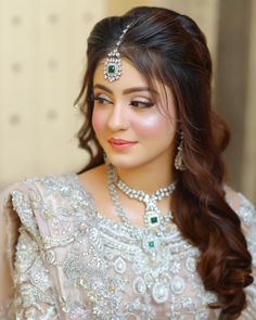 a woman with long hair wearing a tiara and jewelry