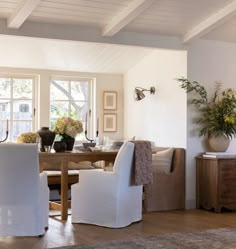 a dining room table with chairs and vases on it