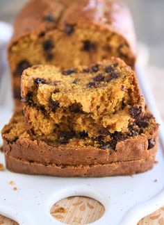 a loaf of chocolate chip pumpkin bread on a cutting board with two slices cut out