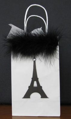 a paper bag with a black fur handle and the eiffel tower on it