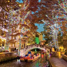 a canal filled with lots of colorful lights next to tall buildings