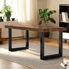 a wooden table sitting on top of a hard wood floor next to a book shelf