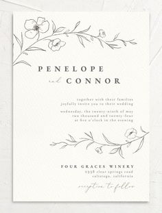 a white and gold wedding card with an elegant floral design on the front, in black ink