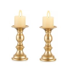 two gold candles sitting next to each other