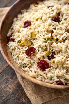 a wooden bowl filled with rice and cranberries