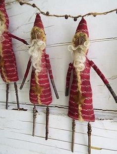 three red santa clause dolls hanging from clothes pins