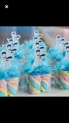 some cupcakes with blue and yellow frosting on them are sitting in small plastic containers