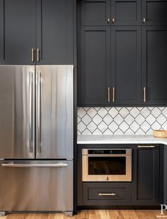 a metallic refrigerator freezer sitting inside of a kitchen next to wooden floors and cabinets