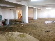 a man standing in an empty parking garage with trash on the ground and debris everywhere