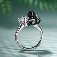 Be fearless and have some fun with this playful piece of panther jewelry. You will add an unforgettable look to your wardrobe and express your unique sense of style at the same time. Crafted in sterling silver, this ring in Hug Me® collection vividly portrays a little cute panther happily hugging a shining white stone. You will find more adorable and creative designs in our Hug Me® collection.Carat Weight: 2.65 ctStone Size: 7 mmStone Type: Jeulia® StoneNumber of Stones: 1 Stone Shape: RoundStone Color: Diamond WhiteCarat Weight: 0.01 ctStone Size: 1 mmStone Type: Jeulia® StoneNumber of Stones: 1 Stone Shape: RoundStone Color: Emerald GreenWeight: 4.76 gMaterial: 925 SilverPlating Color: Silver, Black Silver Cat Design Ring, Silver Cat Design Jewelry For Anniversary, Sterling Silver Cat Design Jewelry For Anniversary, Elegant Cat Design Jewelry Ring, Elegant Cat Design Ring Jewelry, Elegant Silver Jewelry With Cat Design, Elegant Round Ring With Cat Design, Cute Panther, Panther Jewelry