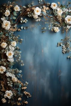 white flowers and greenery are arranged in the shape of a heart on a blue background