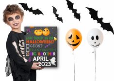 a young boy holding a halloween sign next to two balloons and a trick - or - treat poster