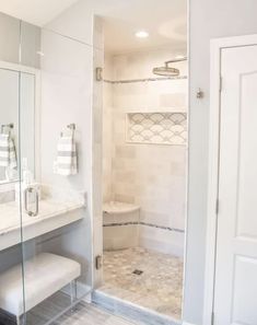 a bathroom with a walk in shower next to a white sink and mirror on the wall