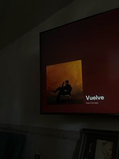 a man sitting on a chair in front of a large television screen with the vuleve logo