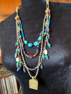 This is a Bohemian Style Necklace that is made of 4 beaded strands that are attached to a woven leather strap that goes around the neck.  There is no closure as you can pull it over your head.   1st strand is made of Turquoise beads and copper beads. 2nd strand is composed of Antique one of a kind Glass Beads and copper beads. 3rd strand is composed of a heavy sterling silver Rolo Chain that multiple handmade turquoise and bead charms have been attached. 4th strand is made of 3mm AFRICAN silver beads, with a pressed metal pendant attached. The appeal is in the necklace as a whole.  I can see this with an arm full of bracelets and some dangle earrings! Pressed Metal, Rolo Chain, Metal Pendant, Style Necklace, Love Necklace, Summer Of Love, Turquoise Beads, Multi Strand, Earring Necklace