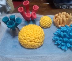 there are many different types of fake corals on the counter top, including one yellow and one blue