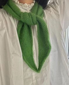 a woman wearing a green knitted scarf