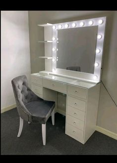 a white vanity with lights on it and a gray chair in front of the mirror