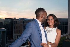 a man and woman standing next to each other in front of a cityscape