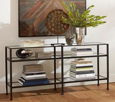 a glass table with books and vase on top