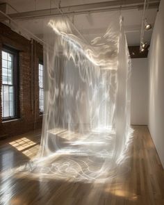 an art installation is shown in the middle of a room with wooden floors and windows