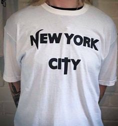 New York City - unisex T-shirt.  This design is available in a choice of colours: -Purple -Black -Red -Green -Blue -Pink -Yellow -Orange Please state the colour design you would prefer in the comments section when ordering.  If no note is left, the design will be the default colour shown in the listing photo (black). The design is available as: -Tshirt -Ringer tee  -Longsleeve -Sweatshirt -Hoody This item has been hand painted and heat fixed to ensure the design lasts. Available in size XXS - 5XL.  (Ringer tees available in size S - 2XL only). I Love Ny T Shirt, I Heart New York Shirt, I Love New York Shirt, Blondie T Shirt, New York Tshirt, New York Graphic Tee, New York Tee Shirt, Ringer Tee, Jaune Orange