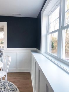 a dining room with white chairs and blue walls