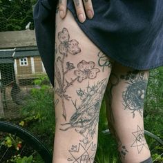 a woman's legs with tattoos and flowers on them