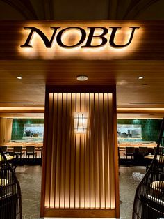 the entrance to nobu restaurant with wooden walls and lighting on it's sides