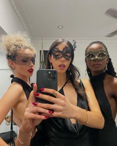 three women wearing masks taking a selfie