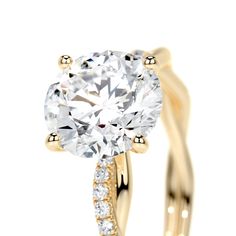 a yellow gold engagement ring with an oval cut diamond in the center and side stones