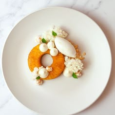 a white plate topped with food on top of a marble countertop next to a knife and fork