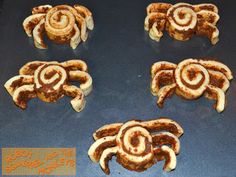 four cookies shaped like crabs on a cookie sheet with words written in the bottom right corner