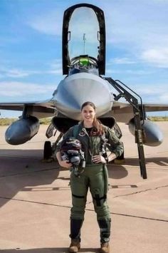 a woman standing in front of a fighter jet