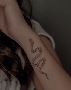 a woman with a snake tattoo on her arm