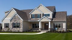 a house with stone and shingles in the front yard