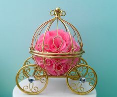 a pink rose in a gold carriage on top of a white cake with the word monogram