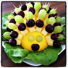 a plate topped with grapes and cheese as a hedgehog