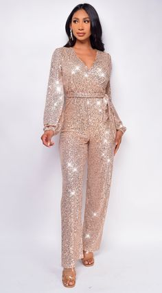 Full length Sequin bodice Surplice front Long sleeve Waist belt Model is wearing size Small Sequin Jumpsuit Outfit Parties, Rose Gold Suits Women, Rose Gold Jumpsuit Wedding, Rose Gold Sequin Pants Outfit, Gold Suit Woman, Rose Gold Outfit Party, Rose Gold Outfit Ideas Casual, White And Gold Jumpsuit, Black And Gold Outfit Parties