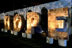 the letters are made out of cardboard and lit up at night in front of a wall