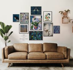 a brown leather couch sitting in front of a wall with pictures on the wall above it