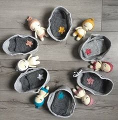 several small stuffed animals are placed in crochet baskets on the floor, each with their own toy