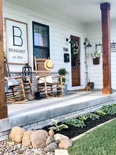 a porch with rocking chairs and plants on the front steps, next to a white house