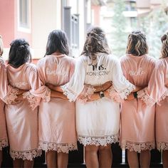 the bridesmaids are wearing pink robes with white laces on their sleeves and shoulders