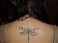 a woman with a dragonfly tattoo on her back