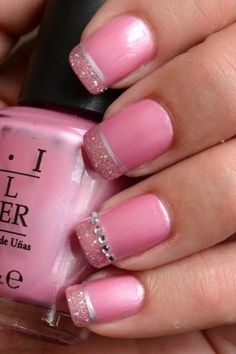 a person with pink and silver nail polish holding a pink manicure on their nails